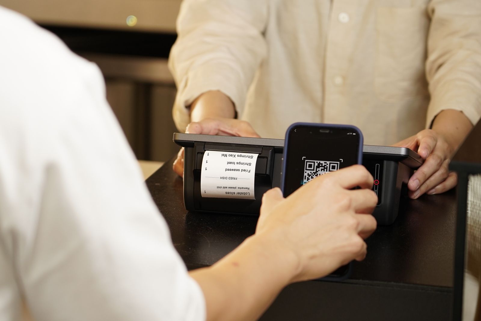 Customer scanning a QR code on a counter with their smartphone